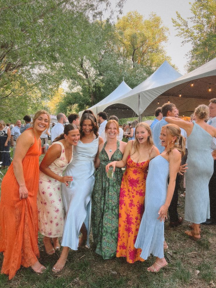 Vriendinnengroep in speelse, kleurrijke jurken op een zomers trouwfeest