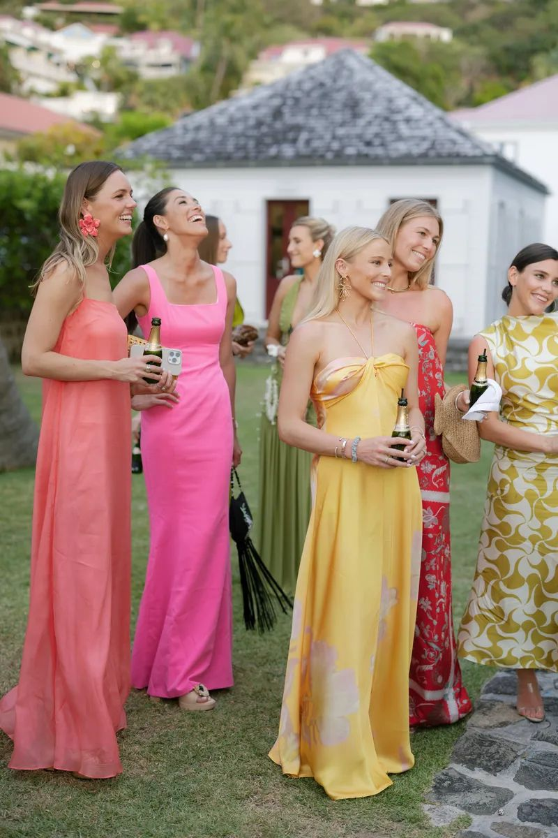 Groep gasten in felle zomerse jurken voor een feestelijke beach chic uitstraling